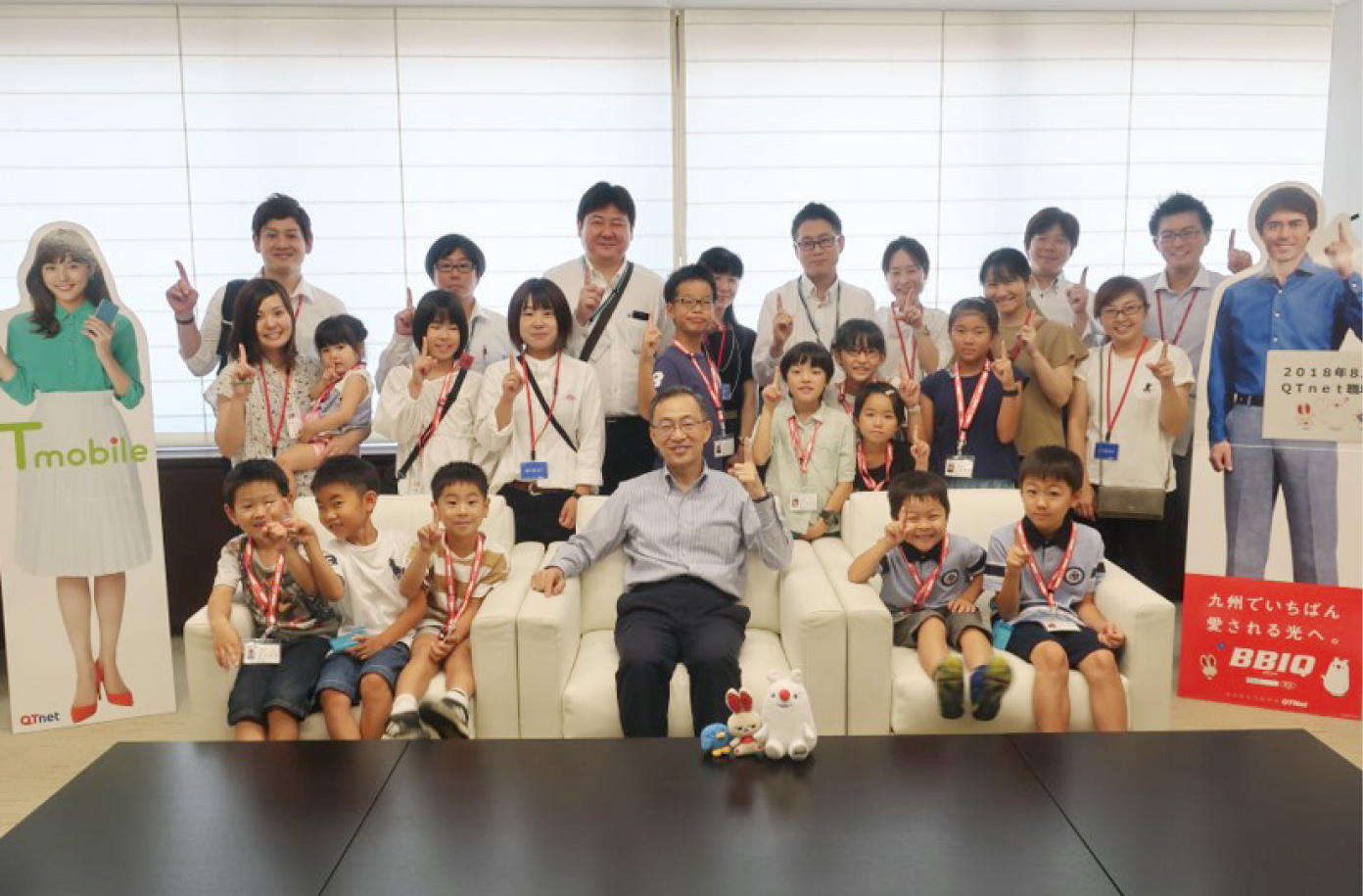 社員とその子供たちとの集合写真。中央の椅子には社長
