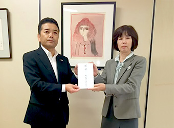 福岡県福祉労働部 山口次長(右)へQTnet総務部長の橋口(左)より贈呈